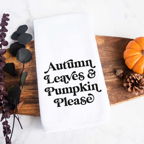 White kitchen tea towel printed with autumn leaves and pumpkin please.  Decorative Towel printed with the text autumn leaves and pumpkin please