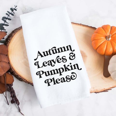 White kitchen tea towel printed with autumn leaves and pumpkin please.  Decorative Towel printed with the text autumn leaves and pumpkin please