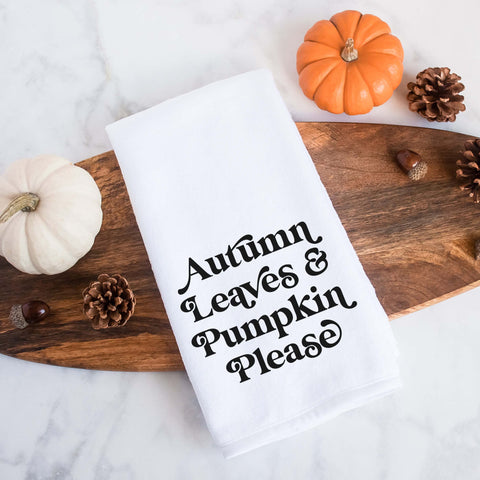 White kitchen tea towel printed with autumn leaves and pumpkin please.  Decorative Towel printed with the text autumn leaves and pumpkin please