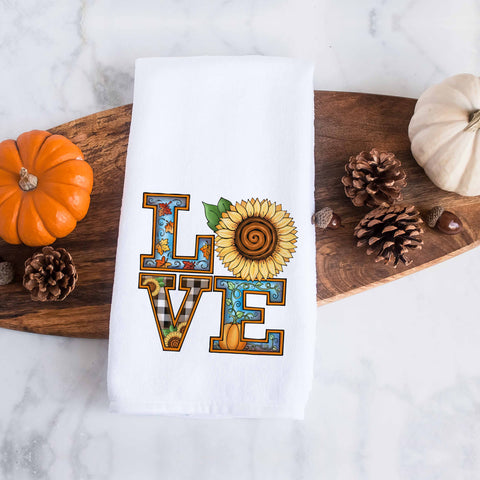 the word love decorated with fall leaves, pumpkins, and sunflowers on a kitchen tea towel, decorative hand towel, modern farmhouse style home decor, kitchen decor, bathroom decor