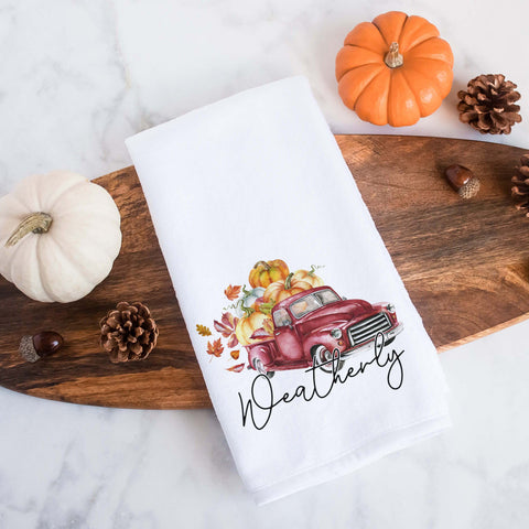 A personalized fall tea towel printed with a fall red truck with pumpkins and the family name underneath.  This can be used as a hand towel, kitchen towel, decorative towel, bathrooom towel, and more.