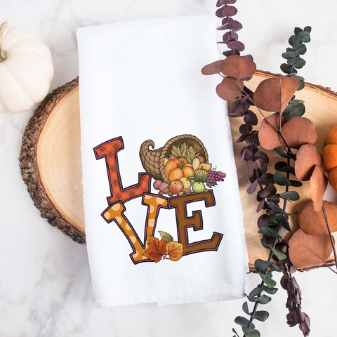 the word love decorated with fall leaves, pumpkins, and thanksgiving cornucopia on a kitchen tea towel, decorative hand towel, modern farmhouse style home decor, kitchen decor, bathroom decor