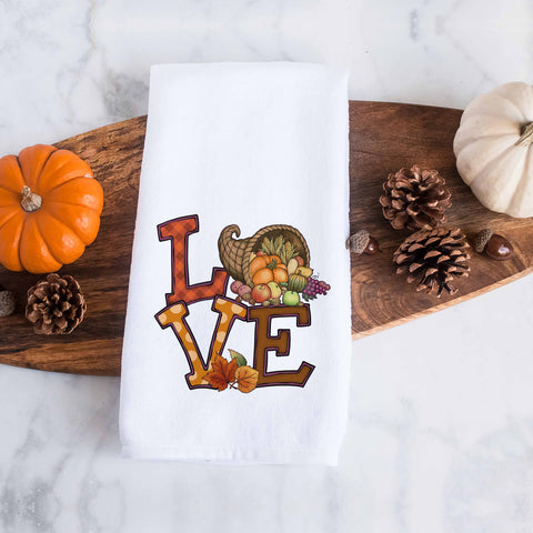 the word love decorated with fall leaves, pumpkins, and thanksgiving cornucopia on a kitchen tea towel, decorative hand towel, modern farmhouse style home decor, kitchen decor, bathroom decor