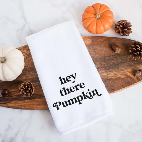 White kitchen tea towel printed with hey there pumpkin.  Decorative Towel printed with the text hey there pumpkin.
