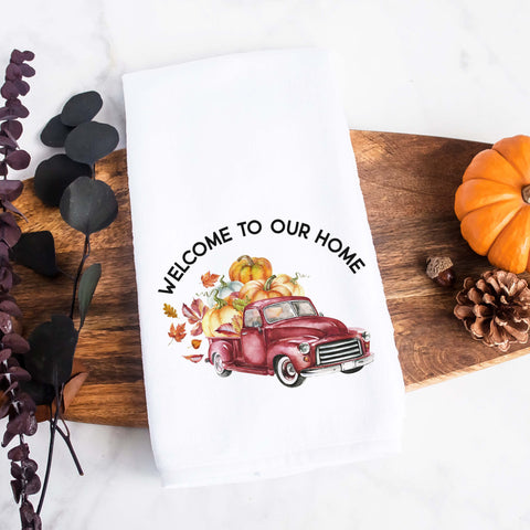 A personalized fall tea towel printed with welcome to our home and a fall red truck with pumpkins and the family name underneath.  This can be used as a hand towel, kitchen towel, decorative towel, bathrooom towel, and more.