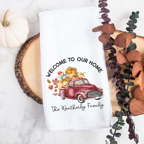 A personalized fall tea towel printed with welcome to our home and a fall red truck with pumpkins and the family name underneath.  This can be used as a hand towel, kitchen towel, decorative towel, bathrooom towel, and more.